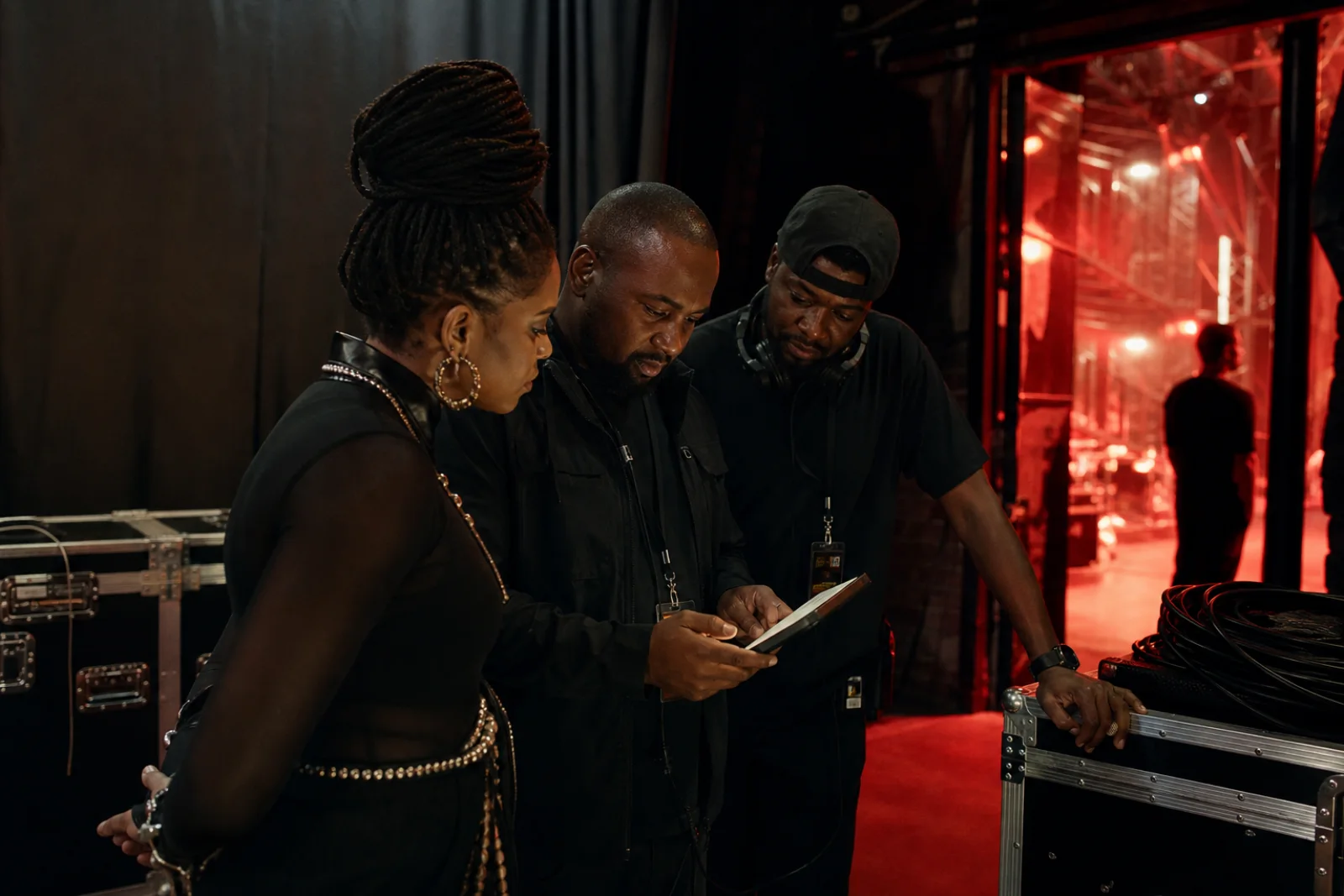 Performer, manager, and production crew reviewing the plan backstage